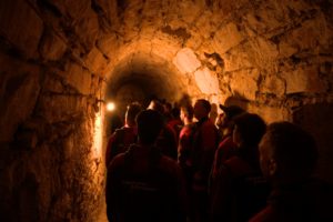 Teammitglieder von Elektro Meister bei einer Führung durch den beleuchteten Tunnel im Munot