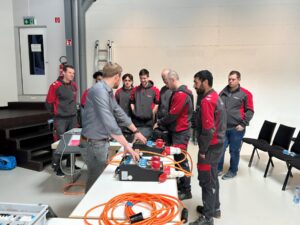 Teilnehmende der Elektro Meister Weiterbildung beim Messkurs mit Präsentation und Schulungsunterlagen.