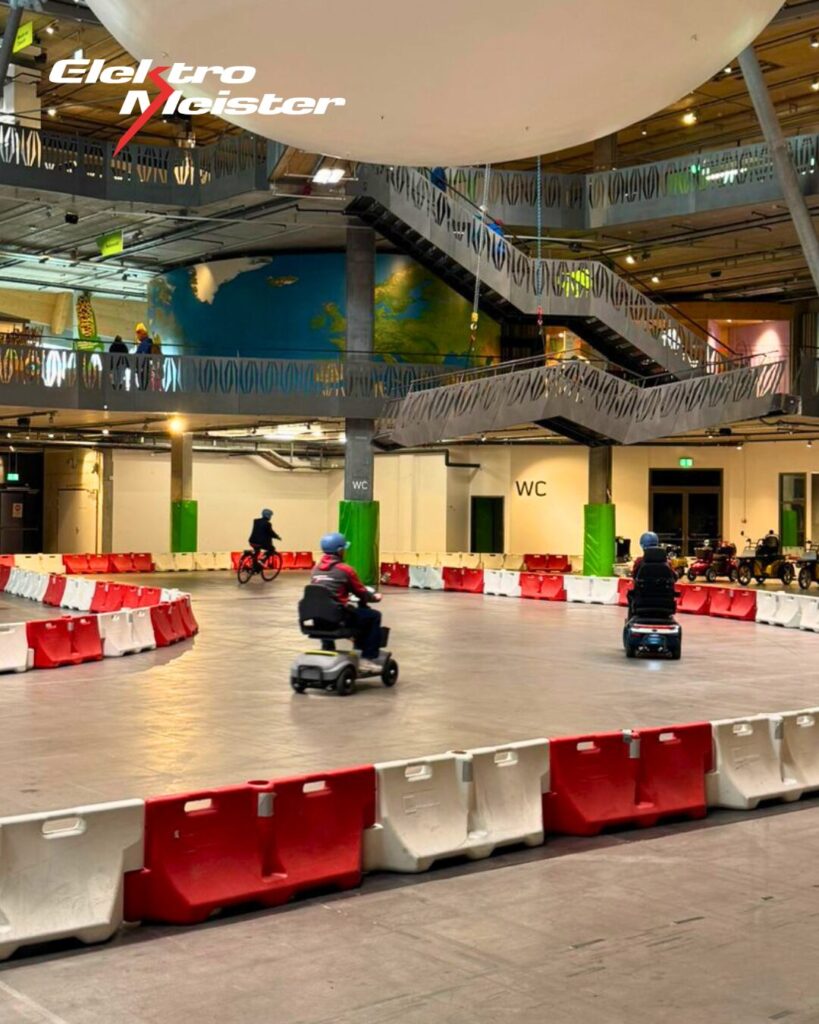 Innenansicht der Umwelt Arena Schweiz mit Teststrecke und verschiedenen Fahrzeugen während des Lehrlingsausflugs.