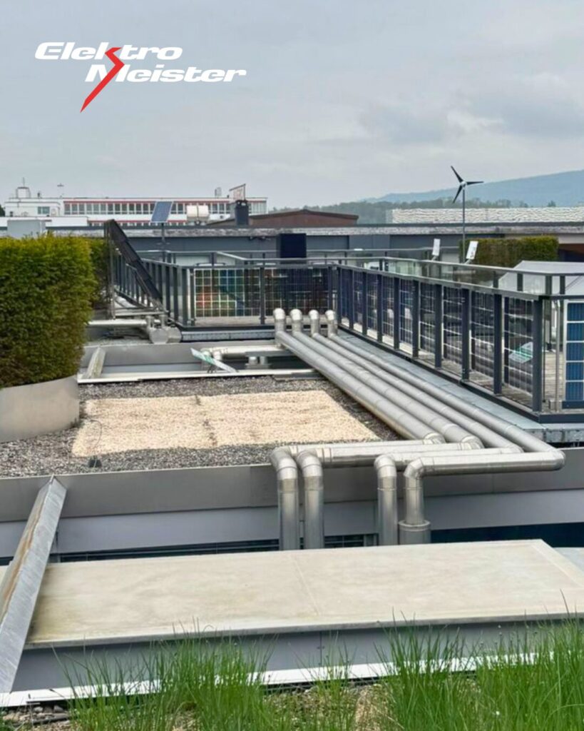 Dachansicht der Umwelt Arena Schweiz mit Leitungen, Solarmodulen und technischer Infrastruktur.